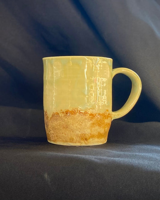 Handthrown ceramic mug, blue green celadon and brillian sunburn glazed with amber- iron oxide washed surface. Two-tone texture, matte and gloss, rock-hammered rugged mountain landscape with a hand-pulled handle.