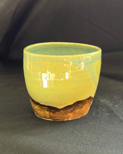 yunomi ceramic tea cup, hand textured rugged rocky mountain landscape, iron oxide wash, celadon blue green sky, wabi sabi.