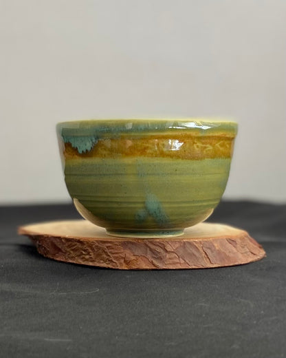 Handcrafted ceramic bowl with smooth celadon glaze and cacao shino detail