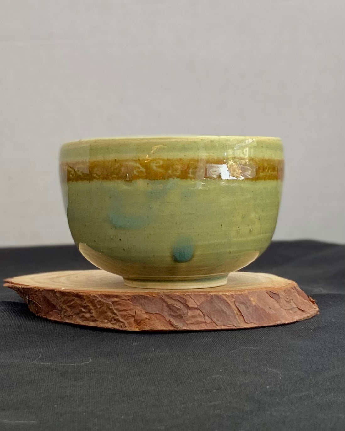 Handcrafted ceramic bowl with smooth celadon glaze and cacao shino detail