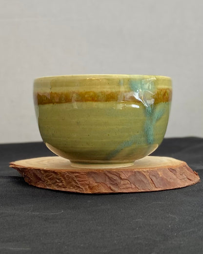 Handcrafted ceramic bowl with smooth celadon glaze and cacao shino detail