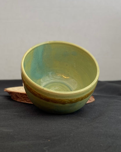 Handcrafted ceramic bowl with smooth celadon glaze and cacao shino detail