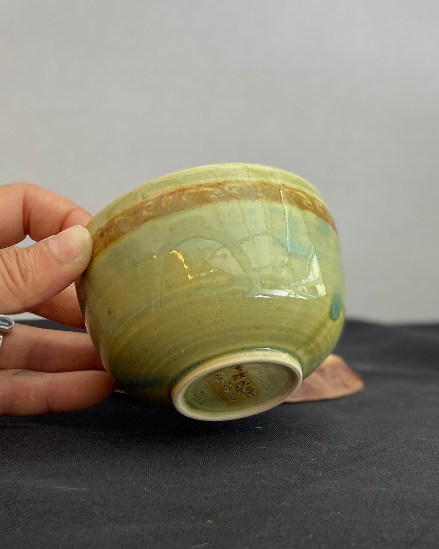 Handcrafted ceramic bowl with smooth celadon glaze and cacao shino detail