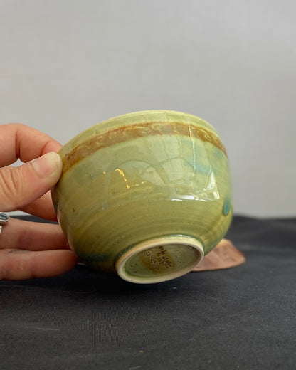 Handcrafted ceramic bowl with smooth celadon glaze and cacao shino detail