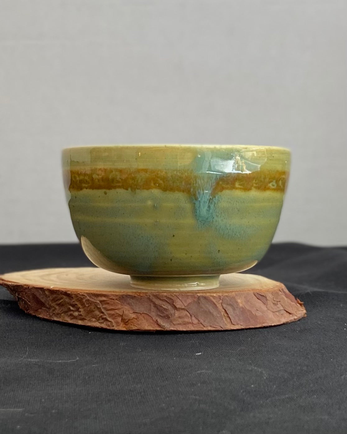 Handcrafted ceramic bowl with smooth celadon glaze and cacao shino detail