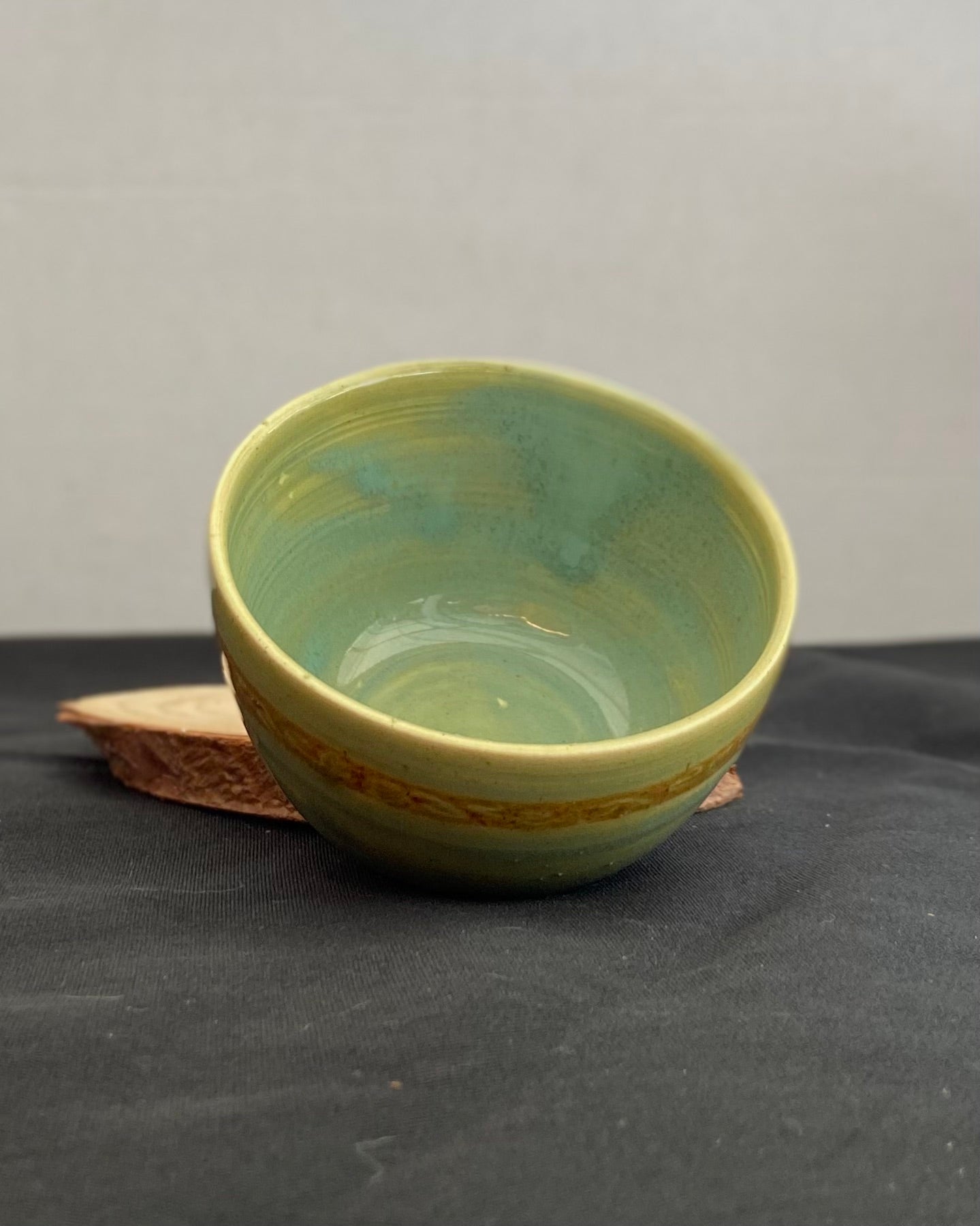 Handcrafted ceramic bowl with smooth celadon glaze and cacao shino detail