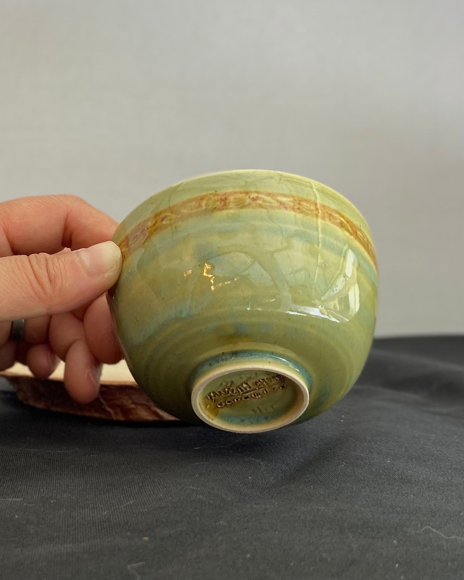 Handcrafted ceramic bowl with smooth celadon glaze and cacao shino detail