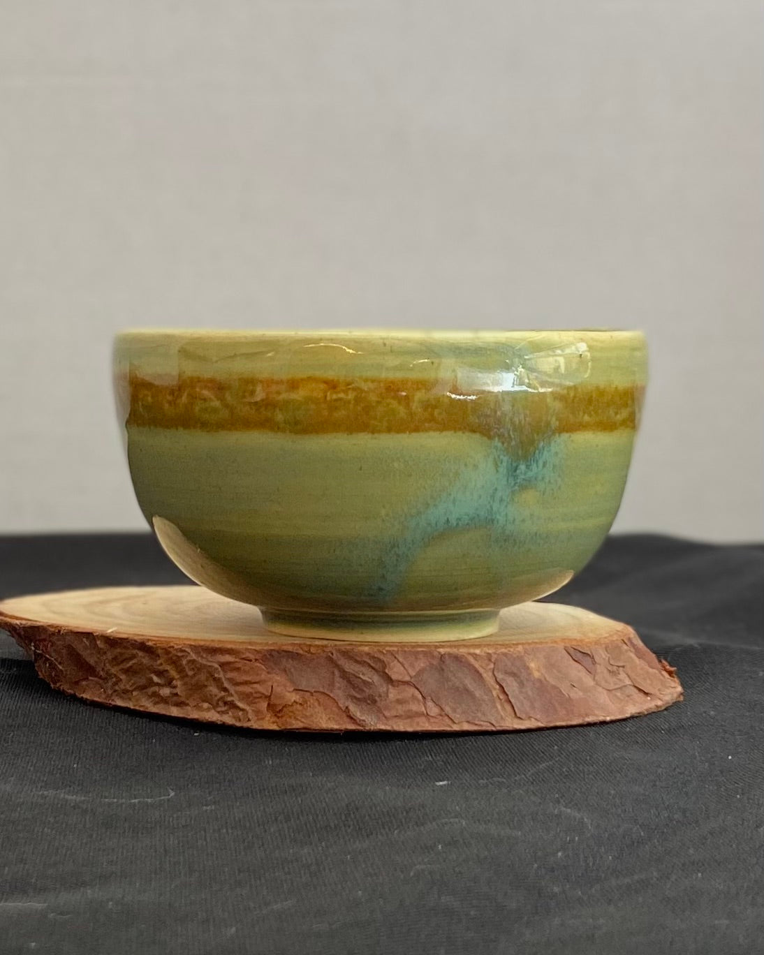 Handcrafted ceramic bowl with smooth celadon glaze and cacao shino detail