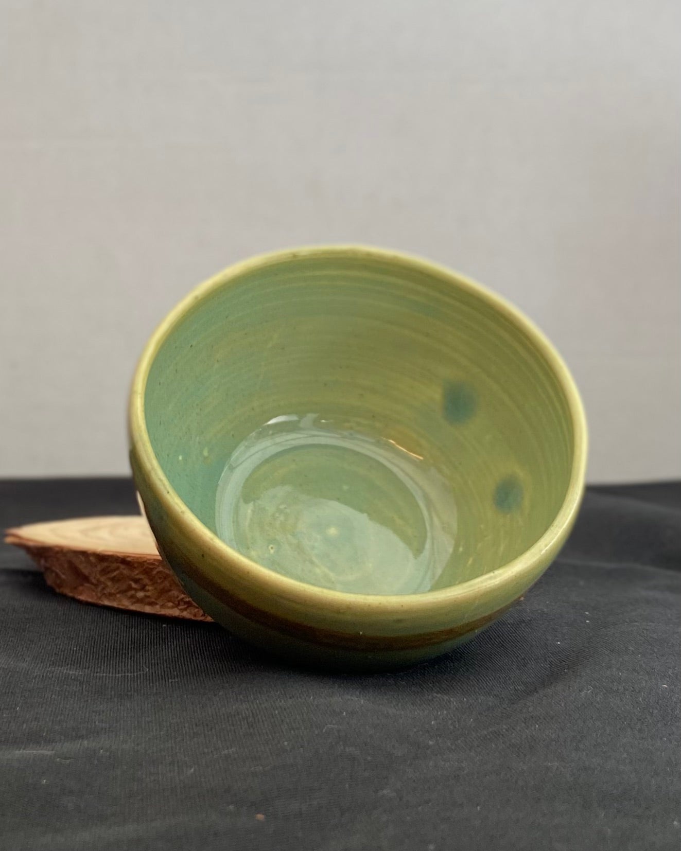 Handcrafted ceramic bowl with smooth celadon glaze and cacao shino detail