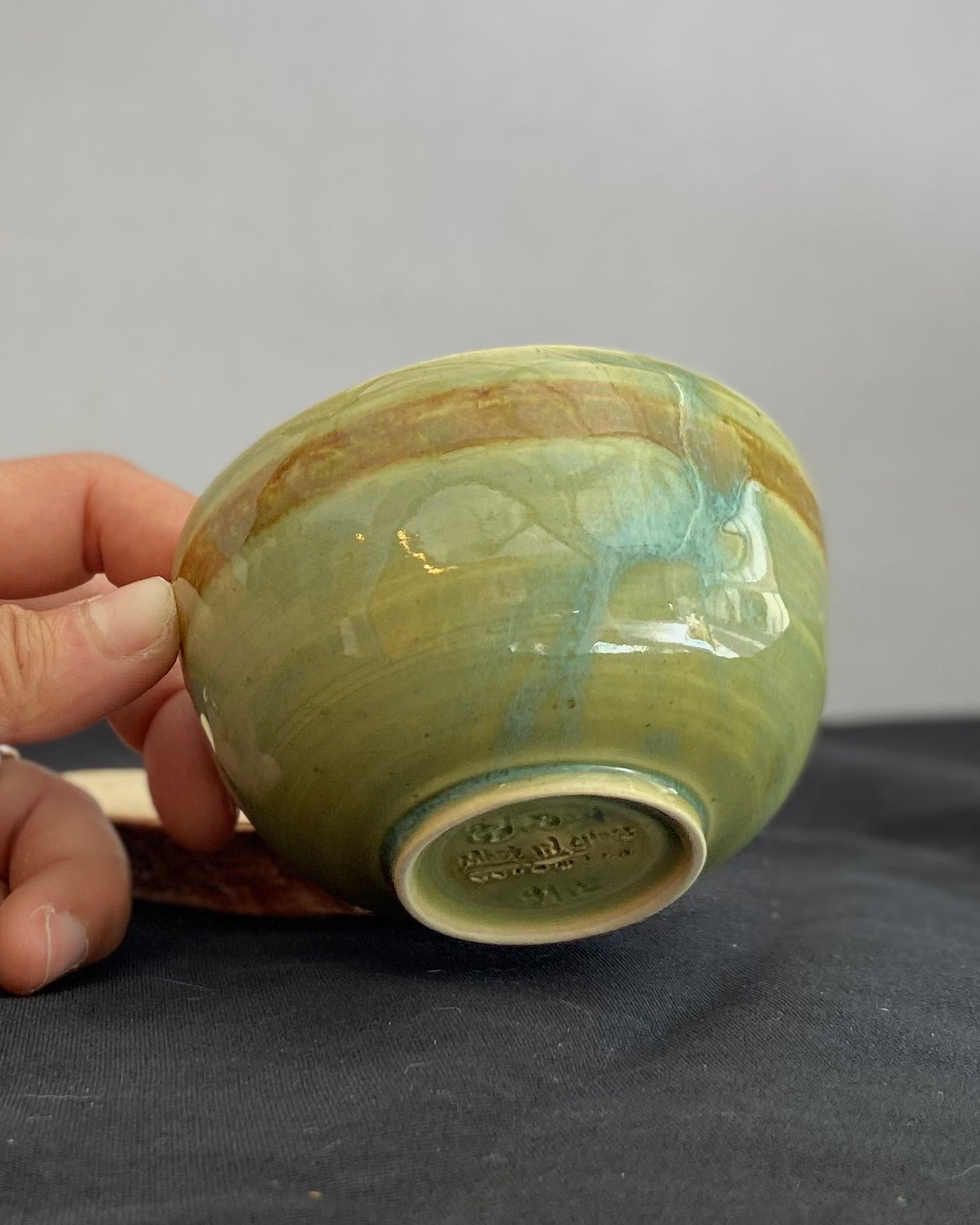 Handcrafted ceramic bowl with smooth celadon glaze and cacao shino detail