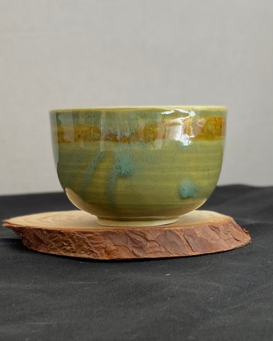 Handcrafted ceramic bowl with smooth celadon glaze and cacao shino detail