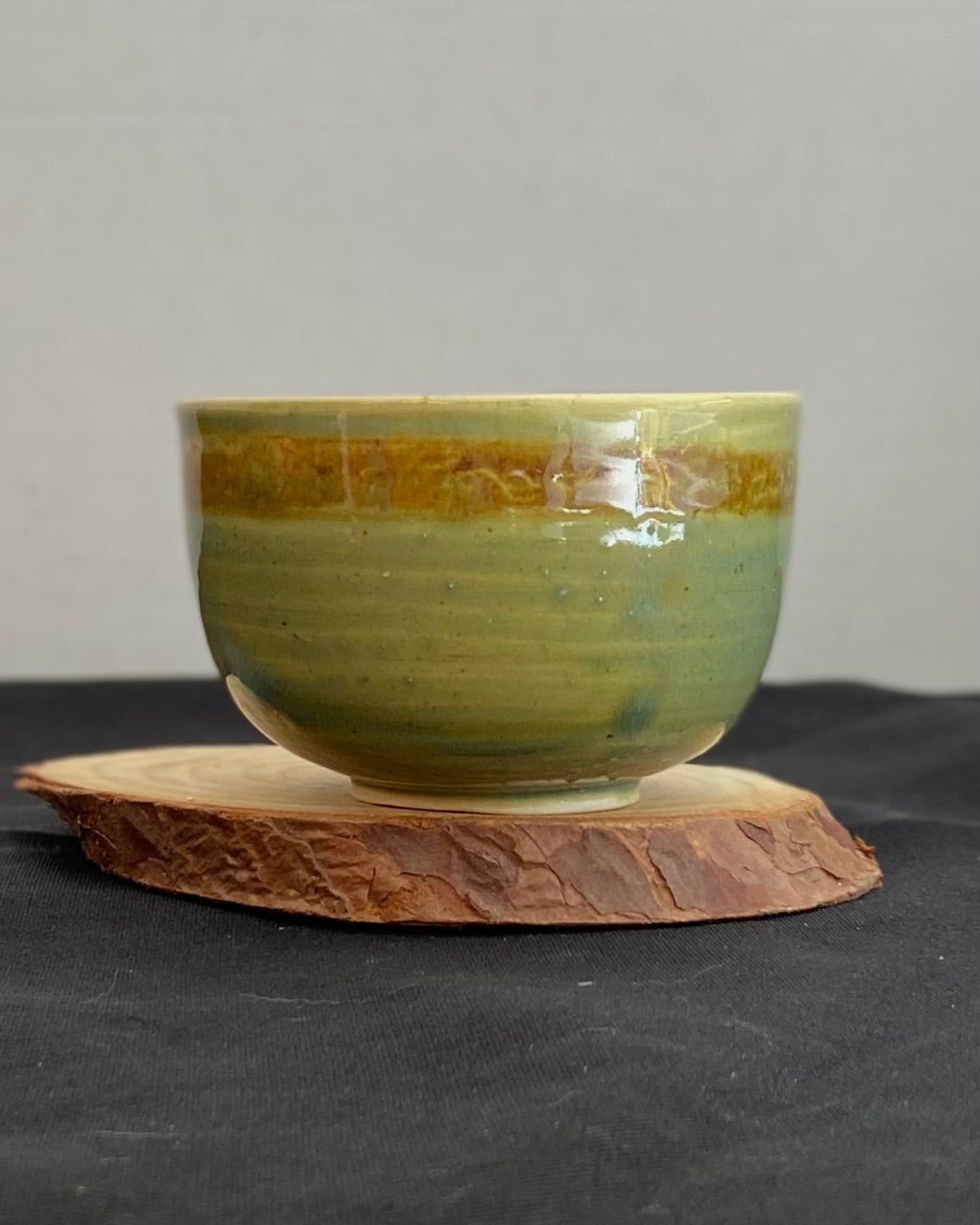 Handcrafted ceramic bowl with smooth celadon glaze and cacao shino detail