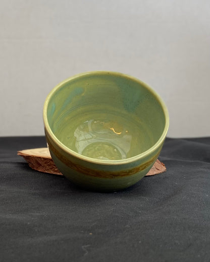 Handcrafted ceramic bowl with smooth celadon glaze and cacao shino detail