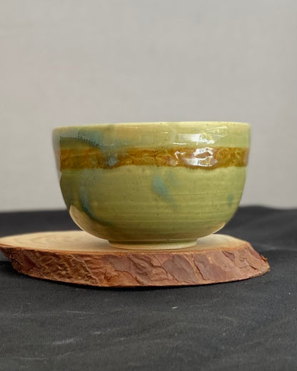 Handcrafted ceramic bowl with smooth celadon glaze and cacao shino detail