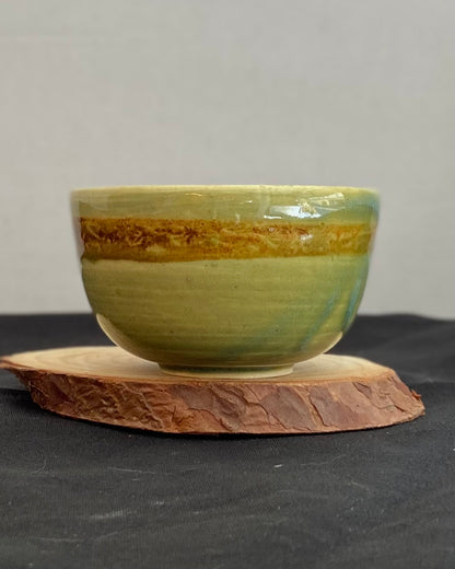 Handcrafted ceramic bowl with smooth celadon glaze and cacao shino detail