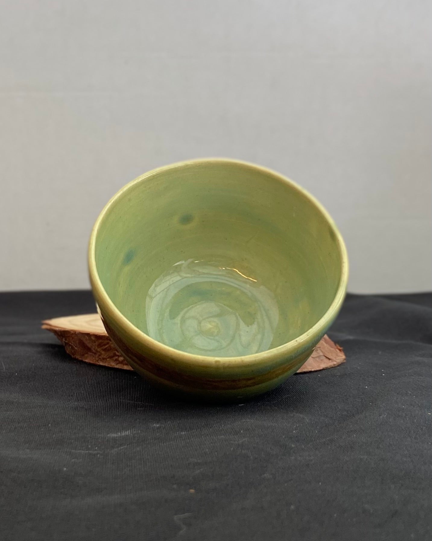 Handcrafted ceramic bowl with smooth celadon glaze and cacao shino detail