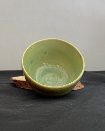 Handcrafted ceramic bowl with smooth celadon glaze and cacao shino detail