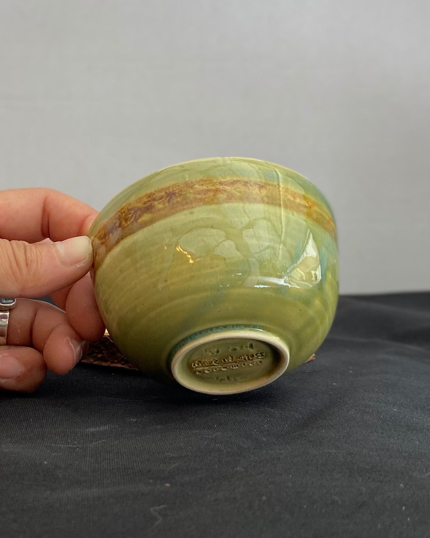 Handcrafted ceramic bowl with smooth celadon glaze and cacao shino detail