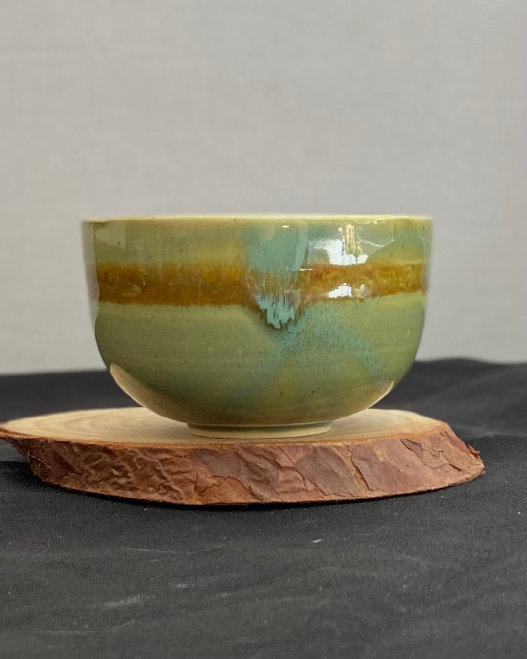 Handcrafted ceramic bowl with smooth celadon glaze and cacao shino detail