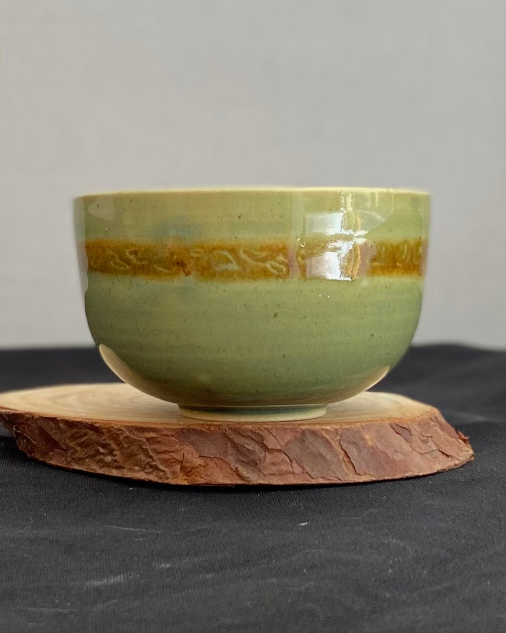 Handcrafted ceramic bowl with smooth celadon glaze and cacao shino detail