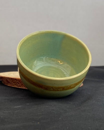 Handcrafted ceramic bowl with smooth celadon glaze and cacao shino detail