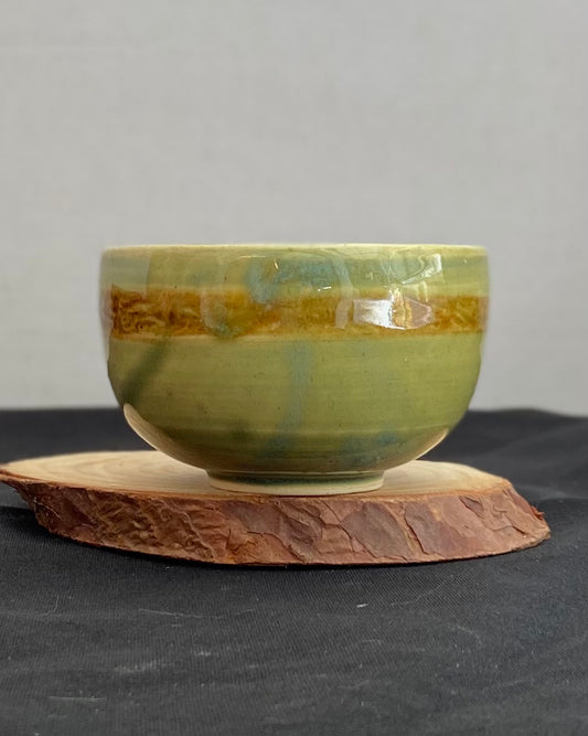 Handcrafted ceramic bowl with smooth celadon glaze and cacao shino detail