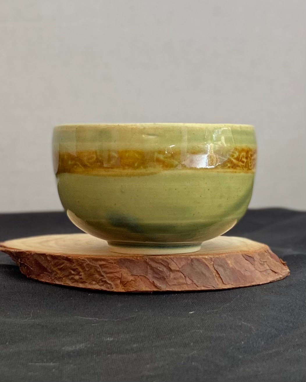 Handcrafted ceramic bowl with smooth celadon glaze and cacao shino detail