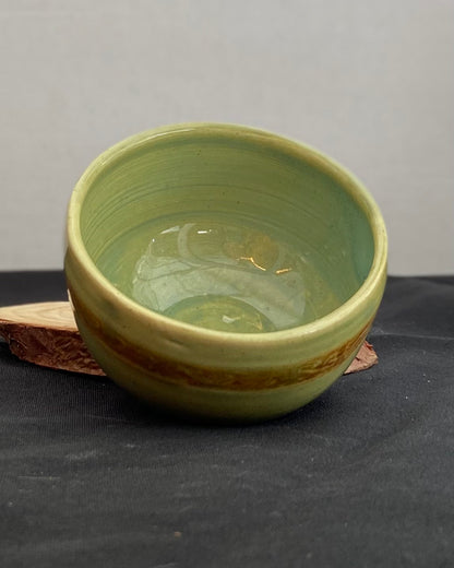 Handcrafted ceramic bowl with smooth celadon glaze and cacao shino detail