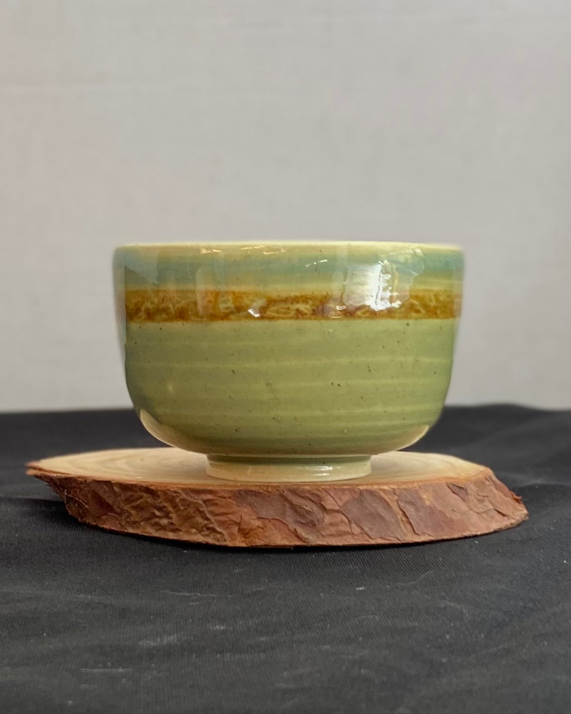 Handcrafted ceramic bowl with smooth celadon glaze and cacao shino detail