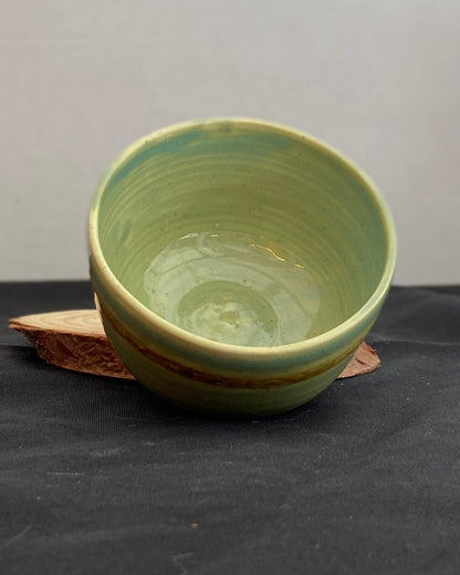 Handcrafted ceramic bowl with smooth celadon glaze and cacao shino detail