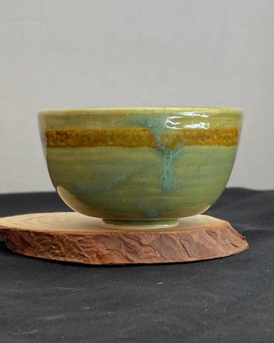 Handcrafted ceramic bowl with smooth celadon glaze and cacao shino detail