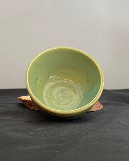 Handcrafted ceramic bowl with smooth celadon glaze and cacao shino detail