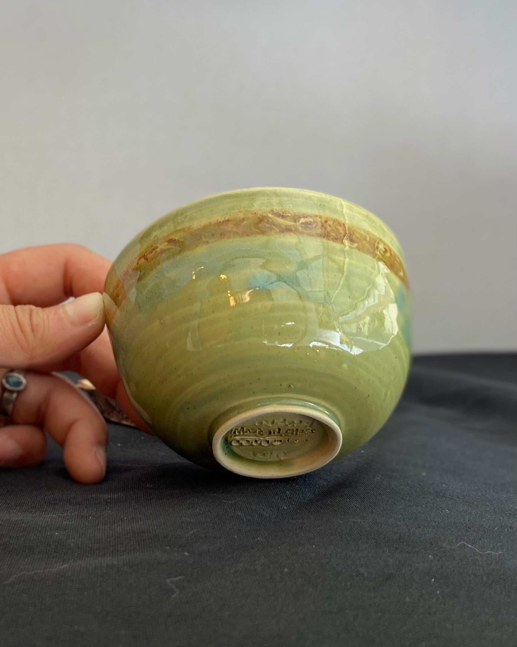 Handcrafted ceramic bowl with smooth celadon glaze and cacao shino detail