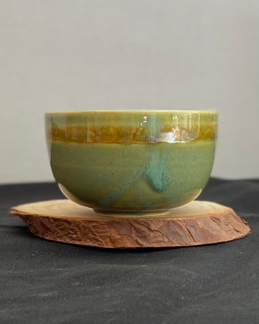 Handcrafted ceramic bowl with smooth celadon glaze and cacao shino detail
