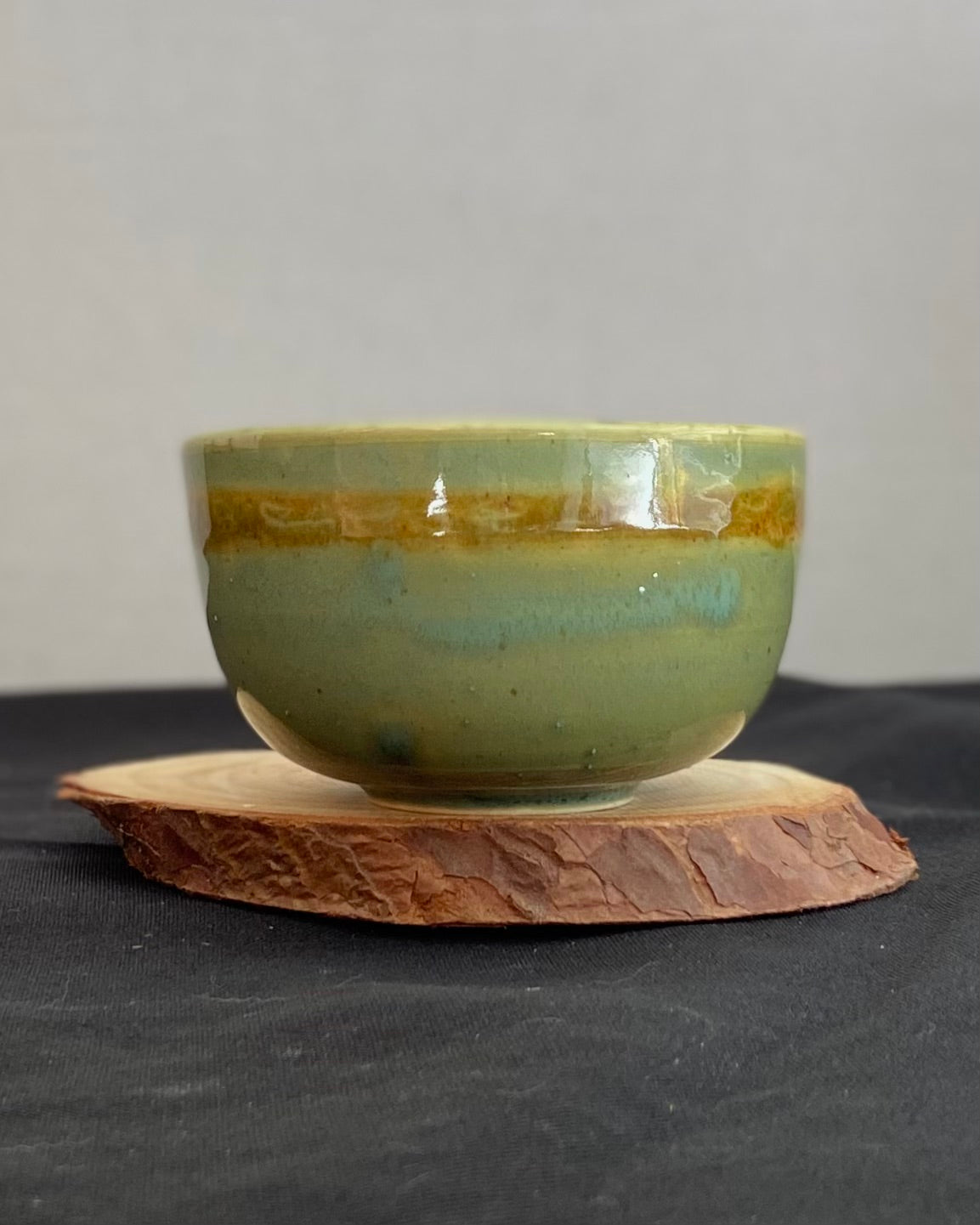 Handcrafted ceramic bowl with smooth celadon glaze and cacao shino detail