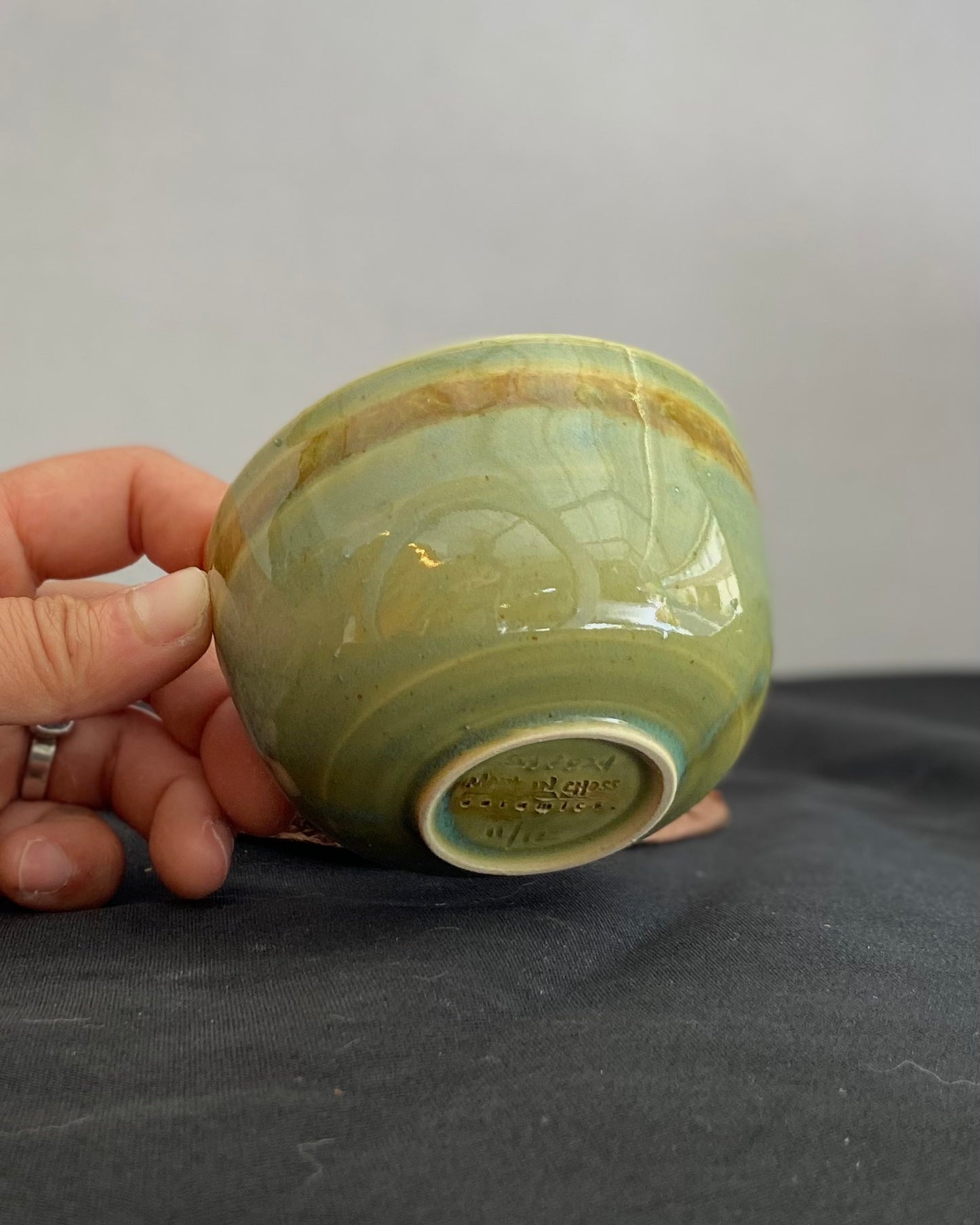 Handcrafted ceramic bowl with smooth celadon glaze and cacao shino detail