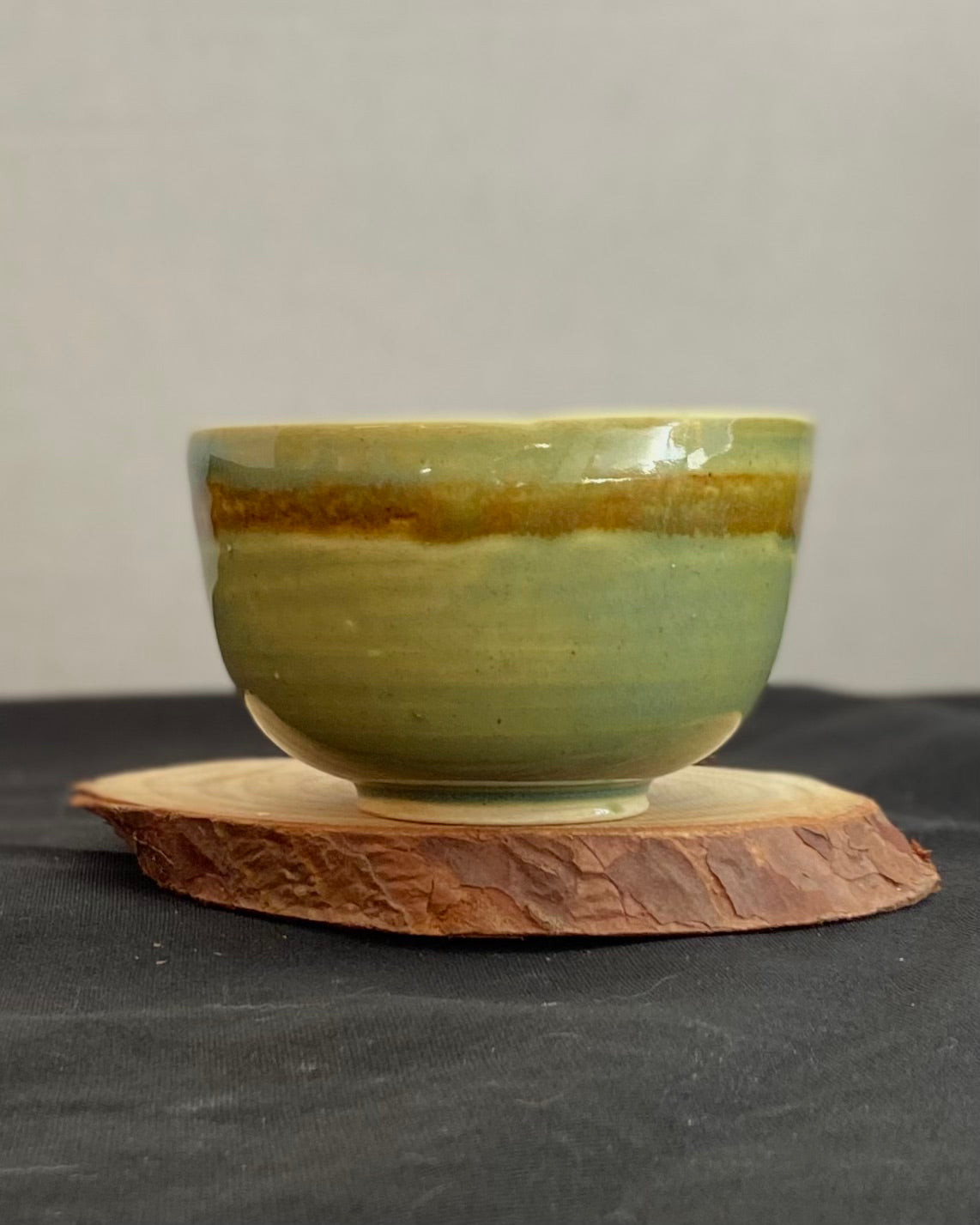 Handcrafted ceramic bowl with smooth celadon glaze and cacao shino detail