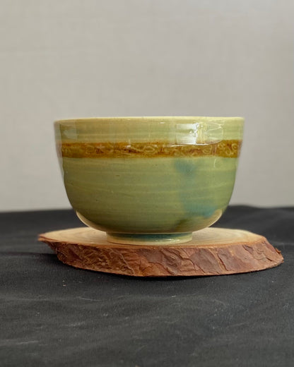 Handcrafted ceramic bowl with smooth celadon glaze and cacao shino detail