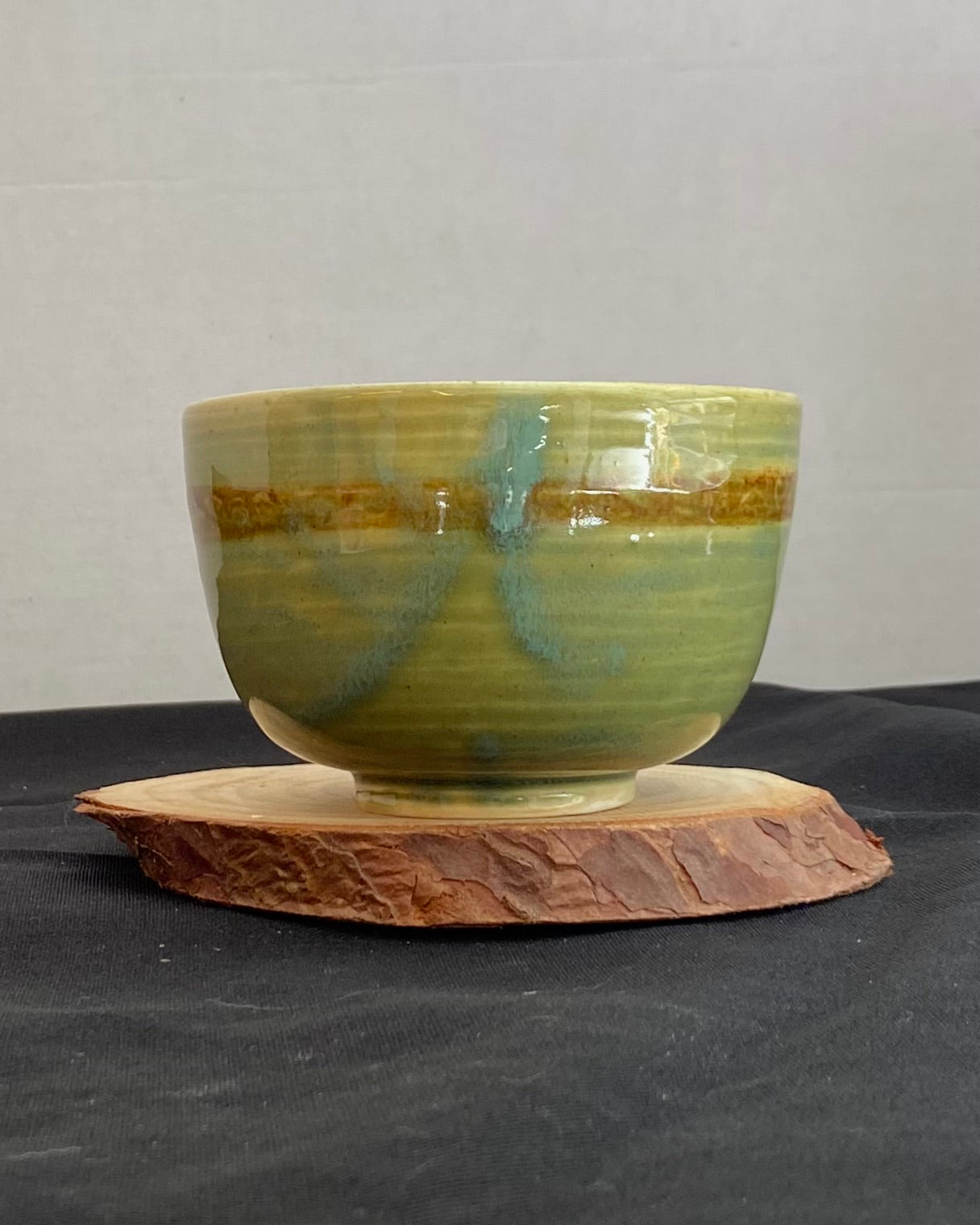 Handcrafted ceramic bowl with smooth celadon glaze and cacao shino detail