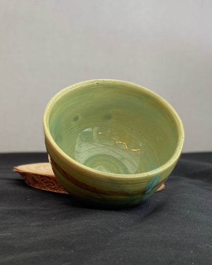 Handcrafted ceramic bowl with smooth celadon glaze and cacao shino detail