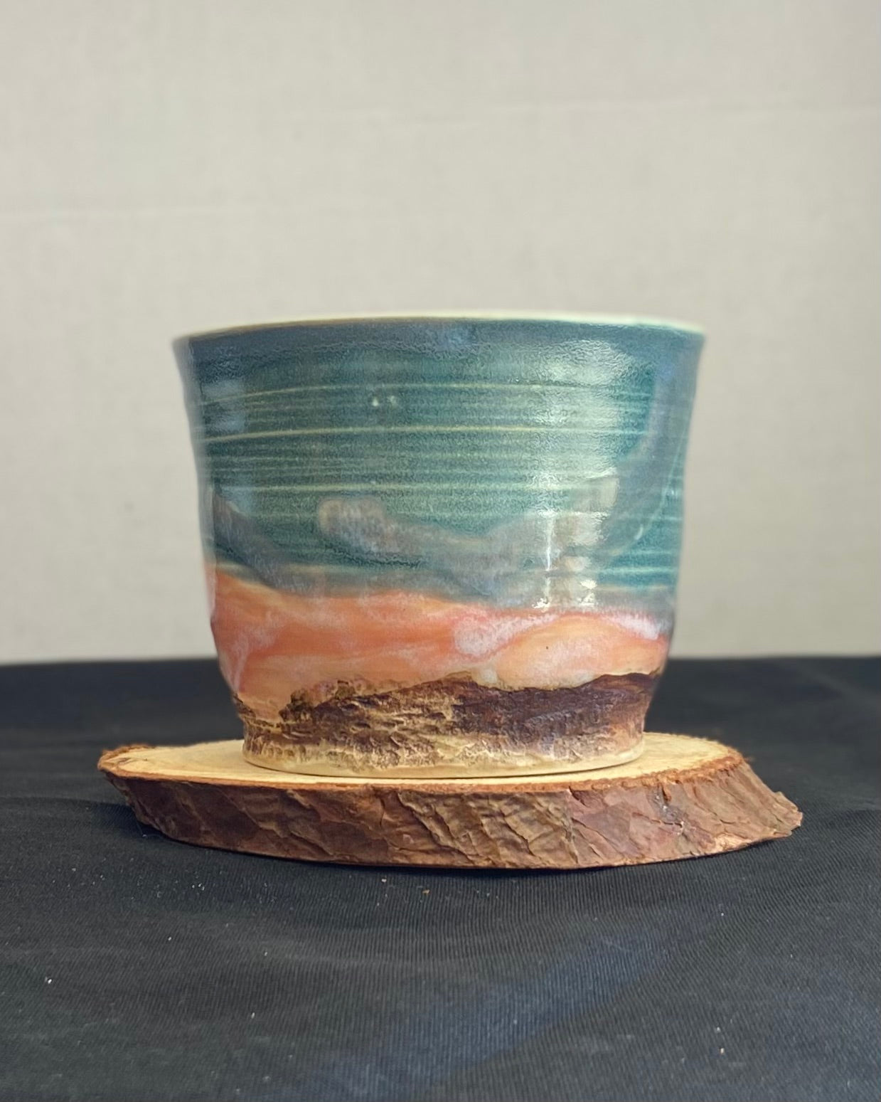 Handcrafted tumbler with hand-etched Joshua tree, antique blue satin glaze, and sunburnt pink glaze creating a sunset over a hand-carved mountain landscape. Unique ceramic tumbler inspired by nature, perfect for beverages. Artisan quality, wabi sabi design, and nature-inspired aesthetic