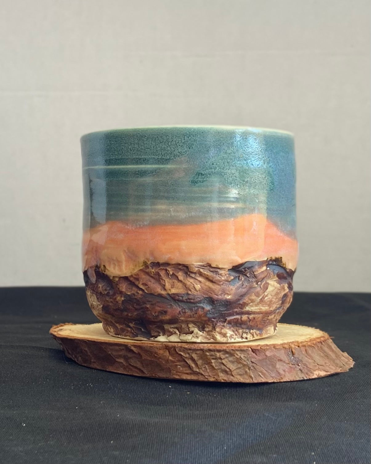 Handcrafted tumbler with hand-etched Joshua tree, antique blue satin glaze, and sunburnt pink glaze creating a sunset over a hand-carved mountain landscape. Unique ceramic tumbler inspired by nature, perfect for beverages. Artisan quality, wabi sabi design, and nature-inspired aesthetic