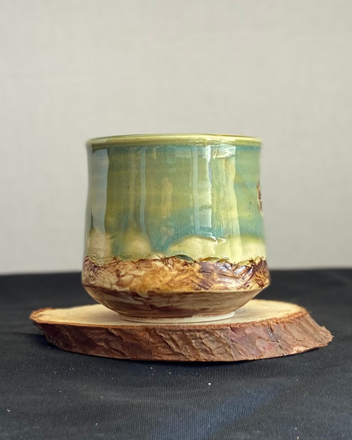 Handcrafted tumbler with hand-etched Joshua tree, celadon blue-green glaze over a hand-carved mountain landscape. Unique ceramic tumbler inspired by nature, perfect for beverages. Artisan quality, wabi sabi design, and nature-inspired aesthetic