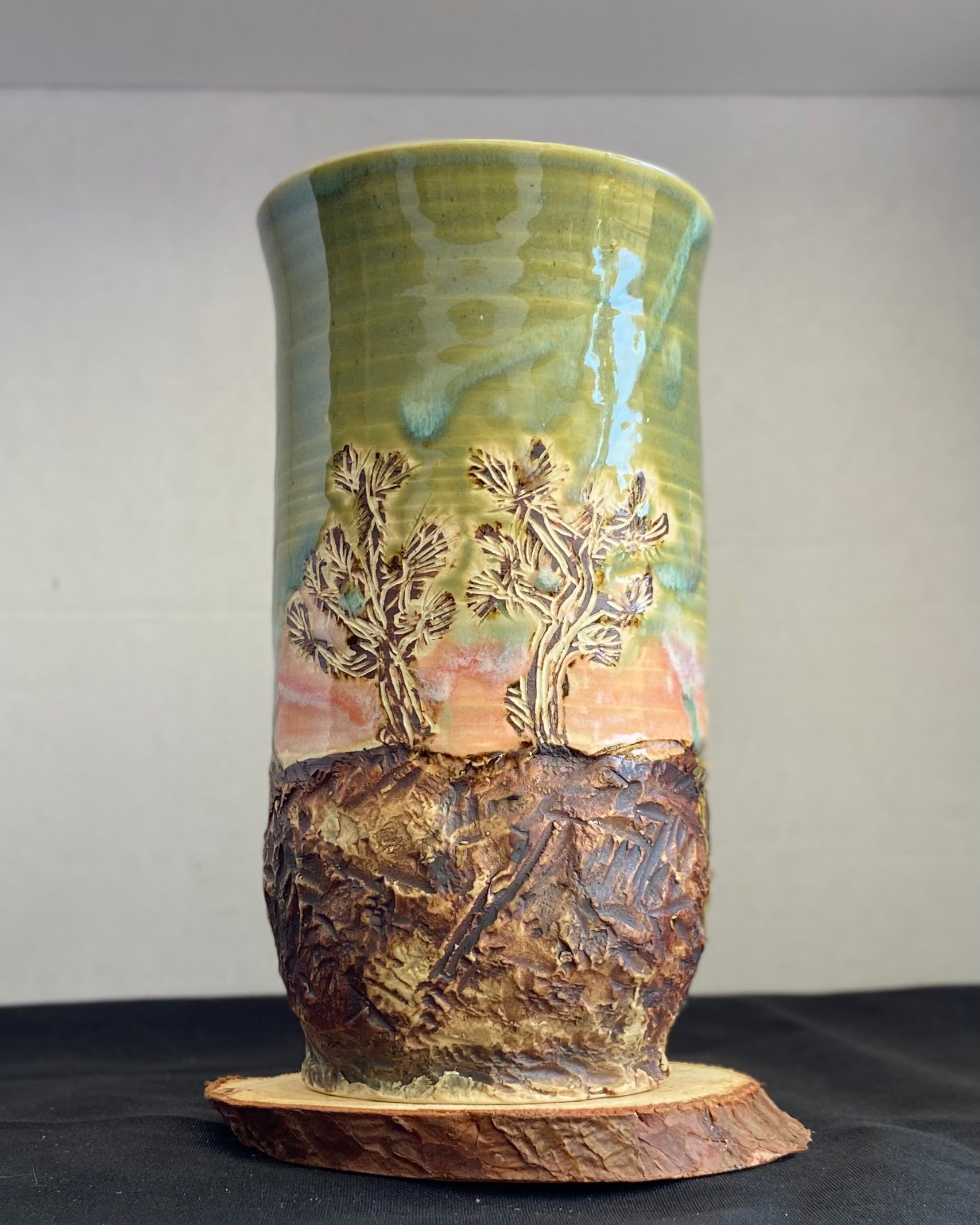 Handcrafted vase with two Joshua trees etched, celadon and pink sunset glaze, and hand-carved landscape. Unique ceramic vase inspired by nature, perfect for displaying flowers or as a decorative piece. Artisan quality, wabi sabi design, and nature-inspired aesthetic