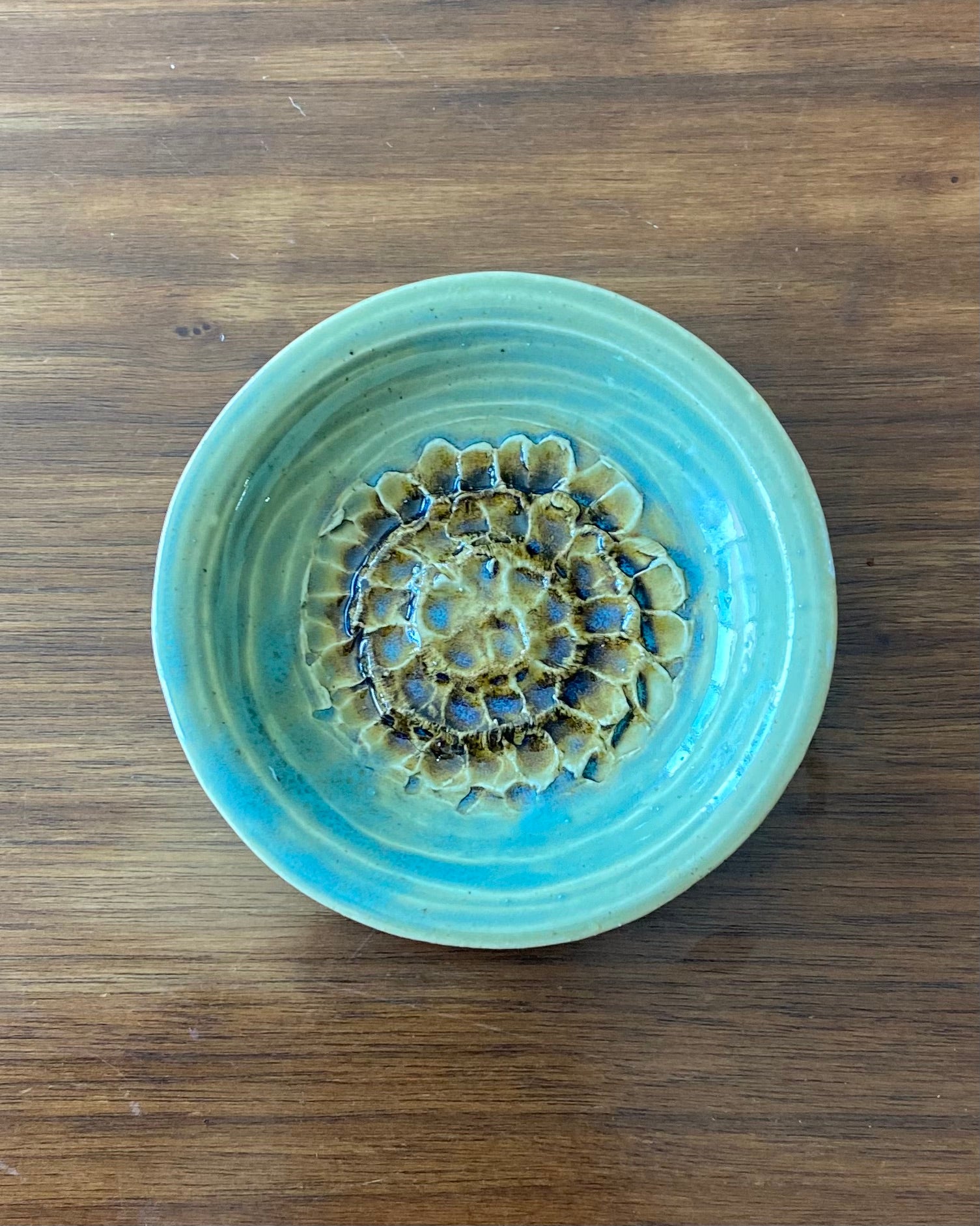 hand crafted, hand carved flower dish, celadon blue glaze with iron oxide accent.