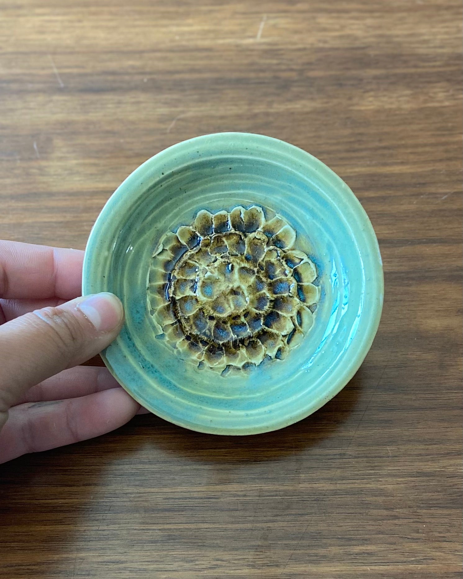 hand crafted, hand carved flower dish, celadon blue glaze with iron oxide accent.